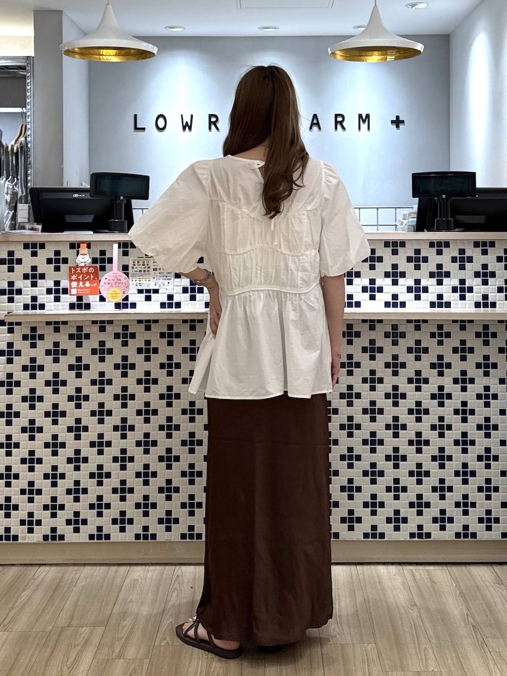 ピンク系のシャツ/ブラウス、ブラウン系のスカート、ブラウン系のサンダルを着用したレディースの夏コーディネートの3枚目の写真