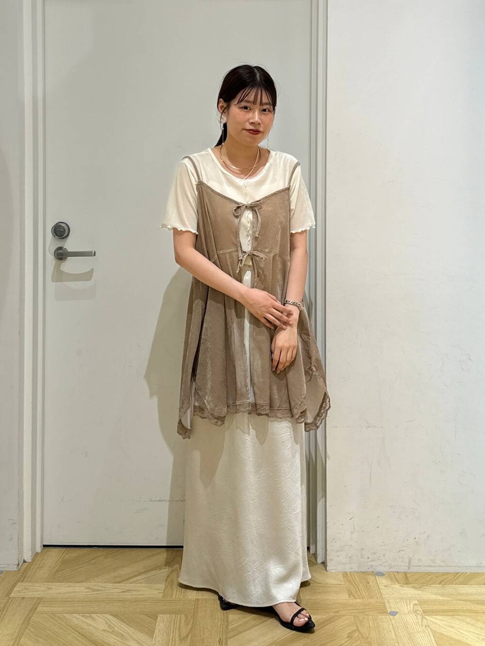 ブラック系のサンダル、ホワイト系のスカート、ホワイト系のカーディガン/ボレロを着用したレディースの夏コーディネートの2枚目の写真