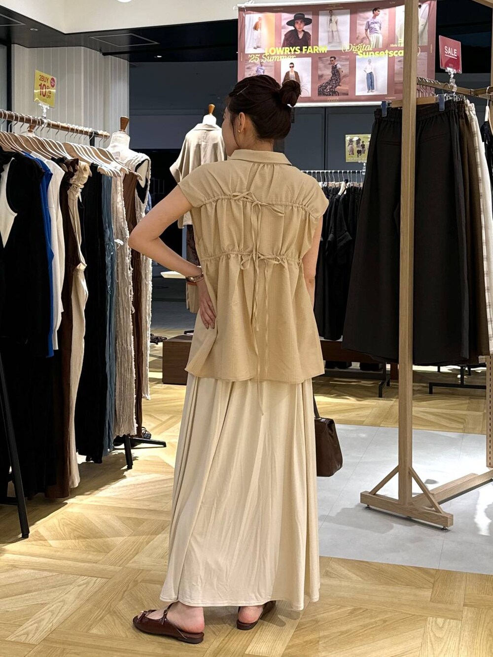 ブラウン系のサンダル、ホワイト系のスカート、ブラウン系のボストンバッグを着用したレディースの夏コーディネートの4枚目の写真