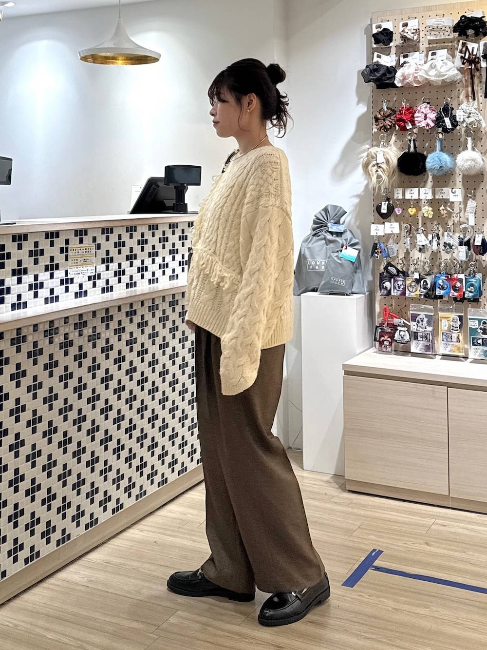 ブラウン系のその他パンツ、ブラック系のローファー、ホワイト系のポロシャツを着用したレディースの秋コーディネートの4枚目の写真