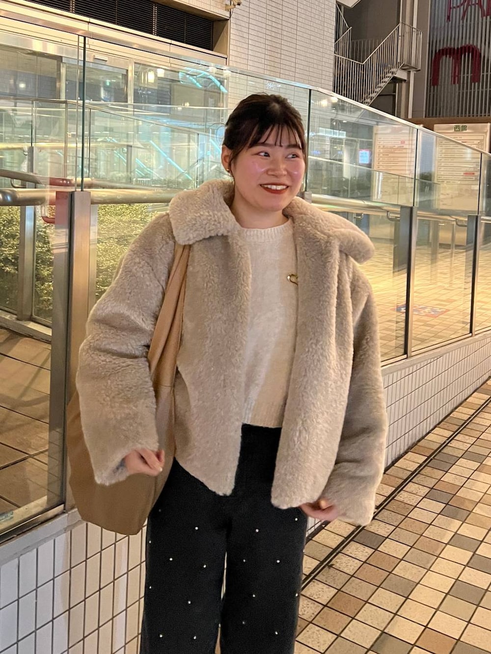 ホワイト系のブルゾン、ホワイト系のニット/セーター、ブラック系のデニムパンツを着用したレディースの冬コーディネートの4枚目の写真