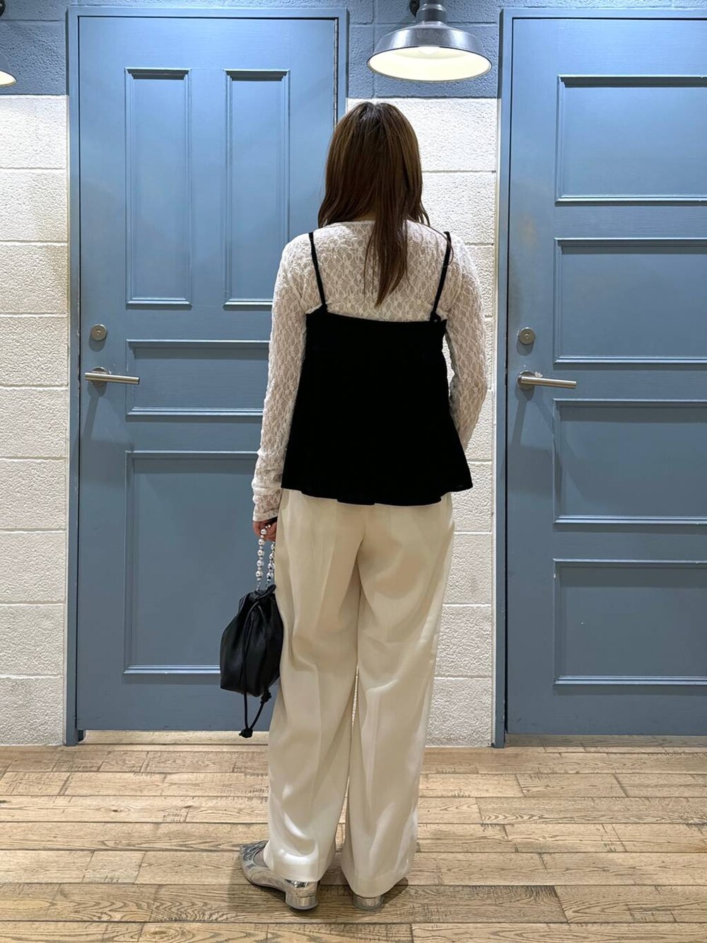 ホワイト系のスラックス、シルバー系のパンプス、ブラック系のショルダーバッグを着用したレディースの秋コーディネートの4枚目の写真