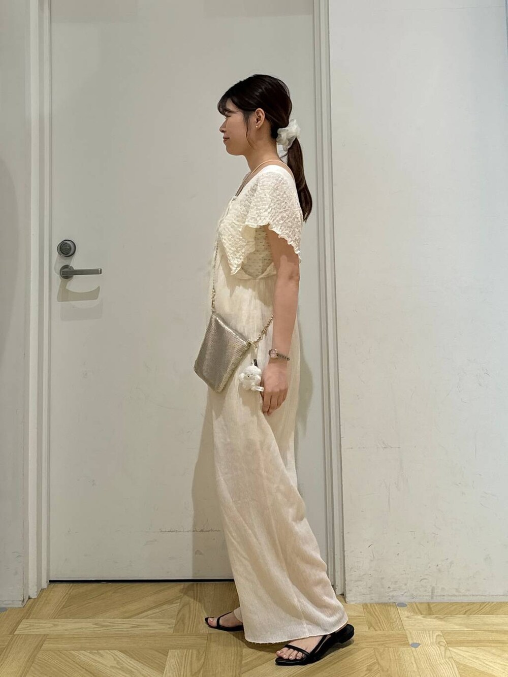 ゴールド系のショルダーバッグ、ブラック系のサンダル、ホワイト系のサロペット/オーバーオールを着用したレディースの夏コーディネートの4枚目の写真