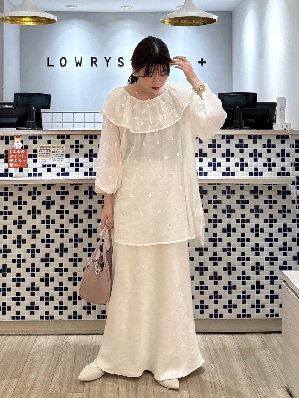 ホワイト系のスカート、ピンク系のショルダーバッグ、ホワイト系のパンプスを着用したレディースの春コーディネートの4枚目の写真