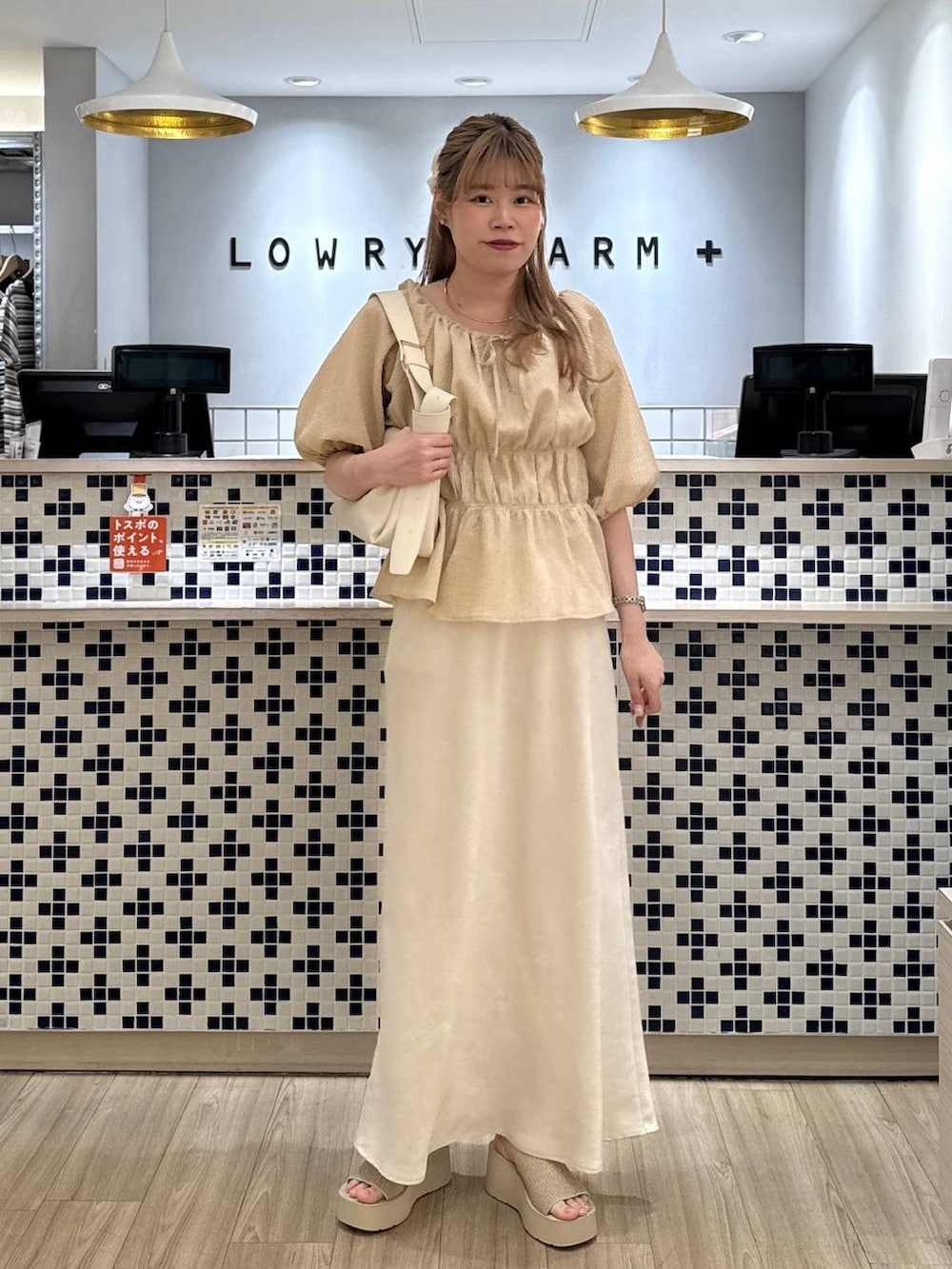 ホワイト系のスカート、ホワイト系のサンダル、ホワイト系のショルダーバッグを着用したレディースの夏コーディネートの3枚目の写真