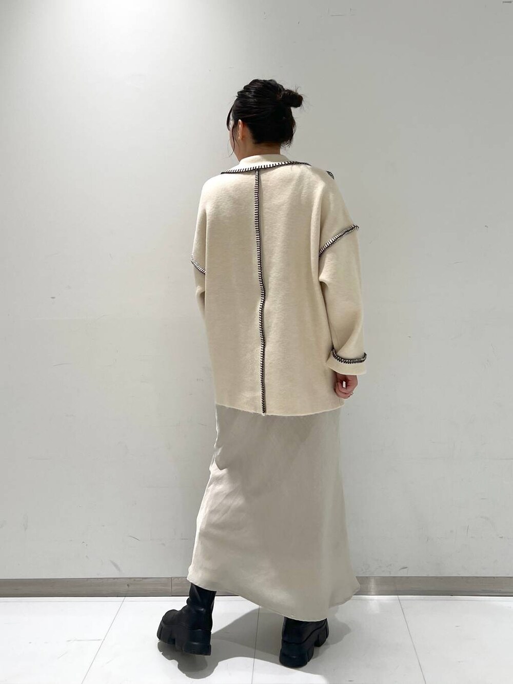 ブラック系のブーツ、ホワイト系のスカート、ホワイト系のカーディガン/ボレロを着用したレディースの秋コーディネートの4枚目の写真