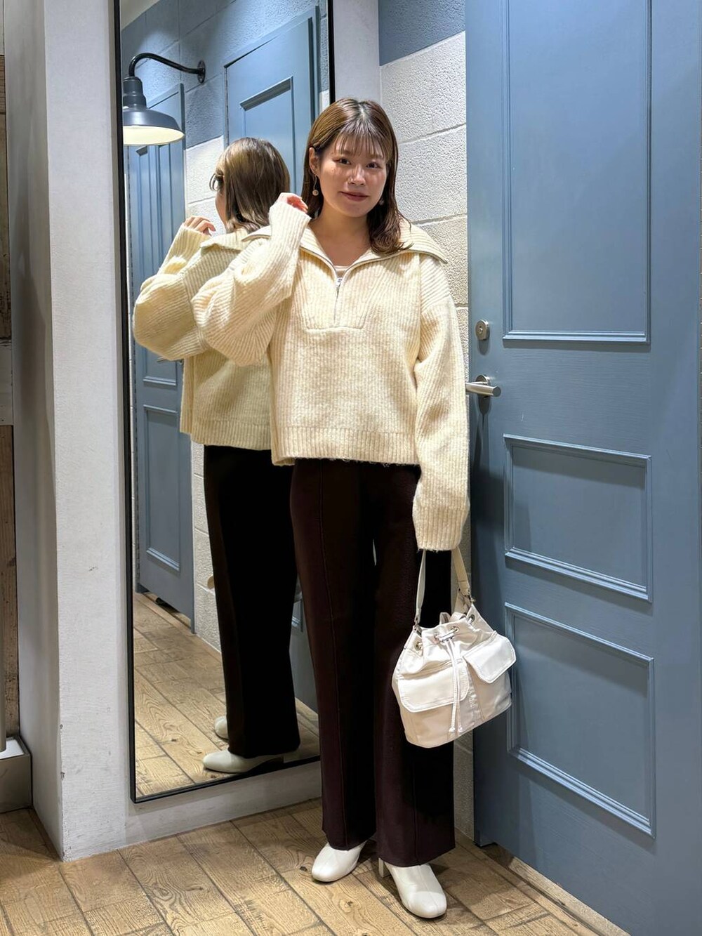 ホワイト系のショルダーバッグ、ホワイト系のブーツ、ホワイト系のニット/セーターを着用したレディースの秋コーディネートの2枚目の写真