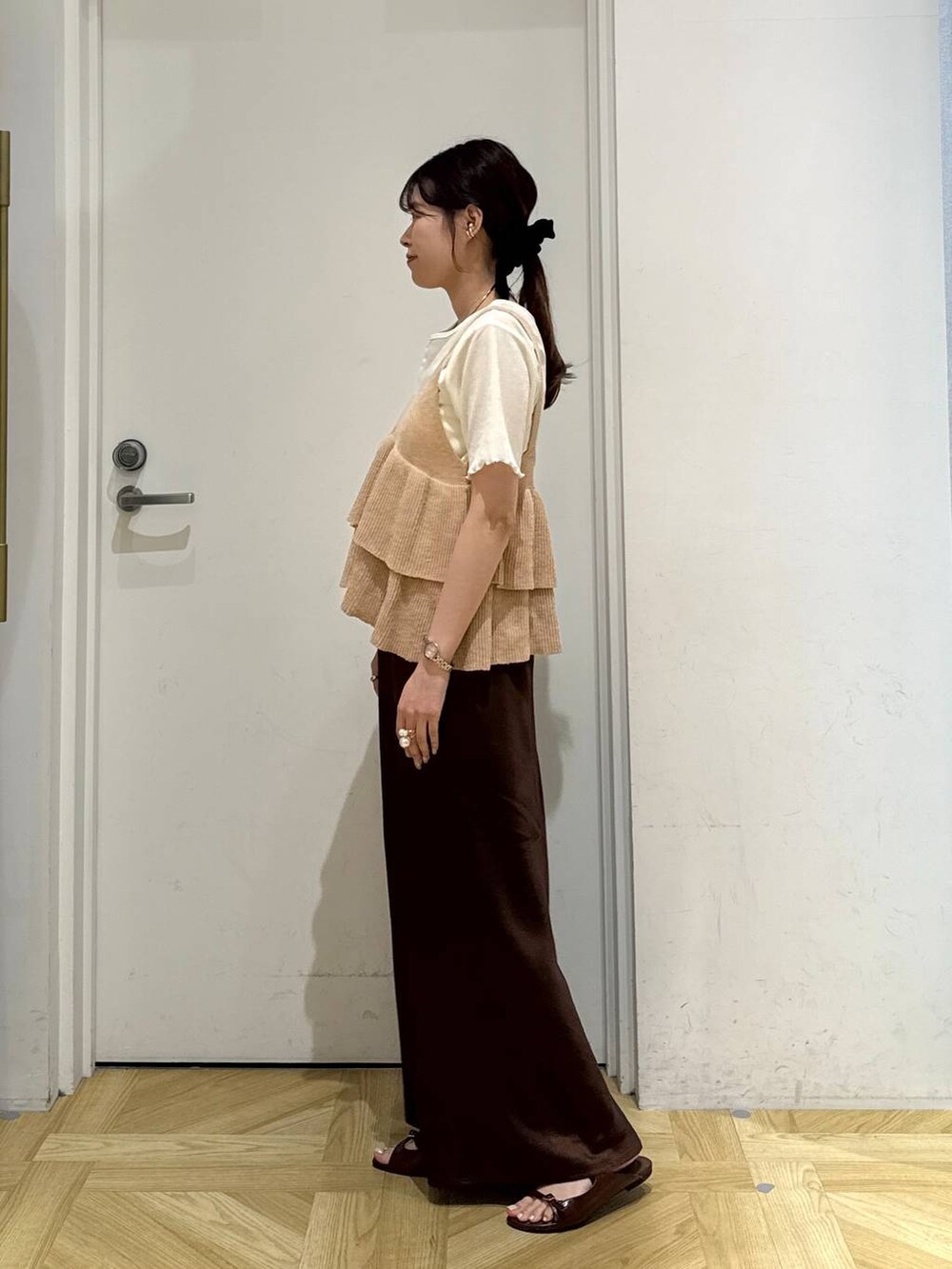 ブラウン系のスカート、ブラウン系のサンダル、ホワイト系のカーディガン/ボレロを着用したレディースの秋コーディネートの3枚目の写真