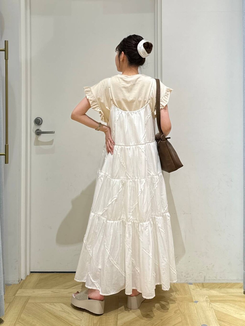 ホワイト系のサンダル、ホワイト系のワンピース、ブラウン系のショルダーバッグを着用したレディースの夏コーディネートの4枚目の写真