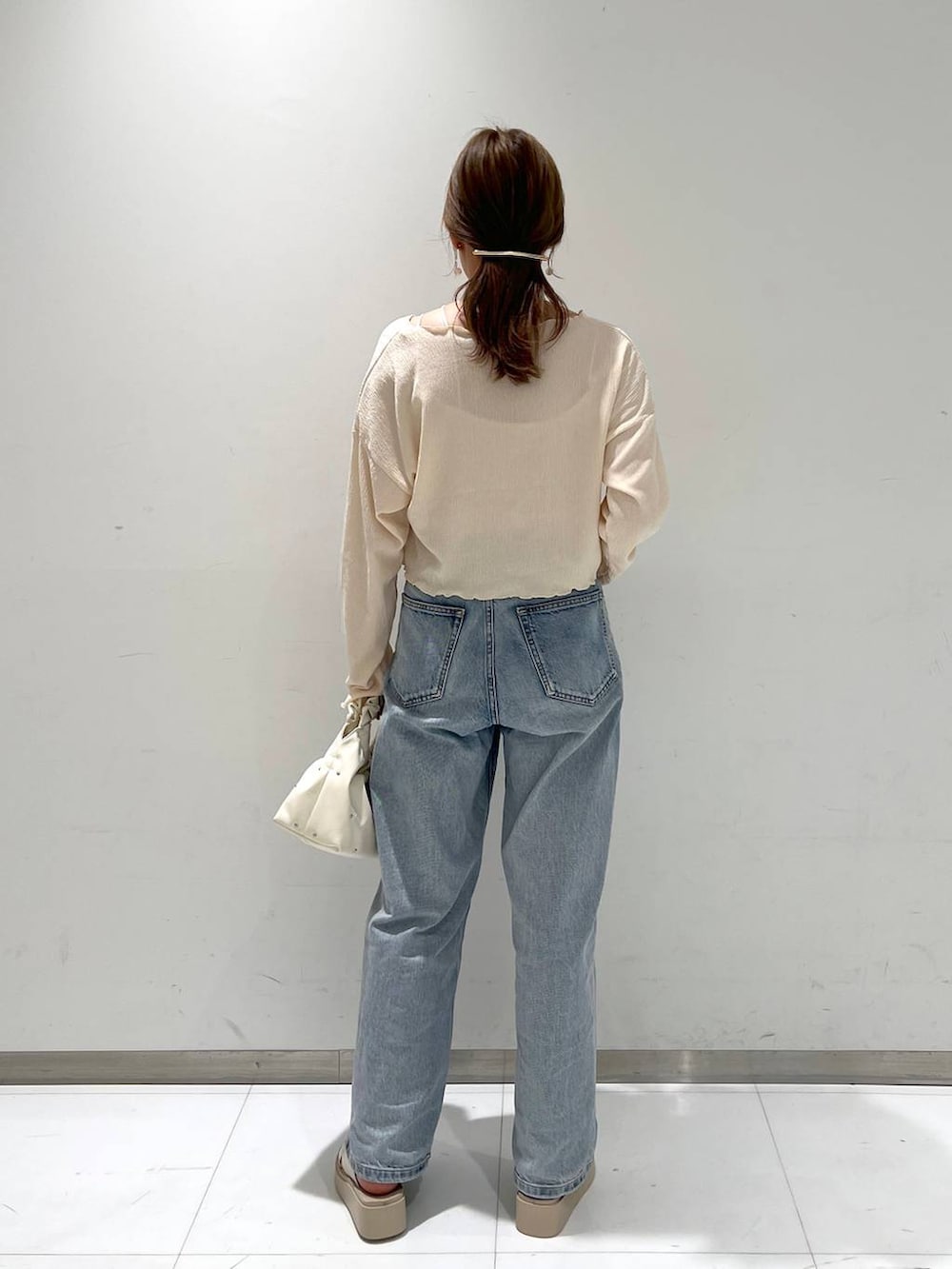 ベージュ系のハンドバッグ、ホワイト系のサンダル、ホワイト系のタンクトップを着用したレディースの夏コーディネートの3枚目の写真