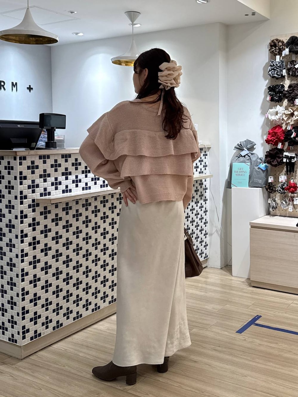 ホワイト系のスカート、ブラウン系のブーツ、ブラウン系のショルダーバッグを着用したレディースの冬コーディネートの5枚目の写真