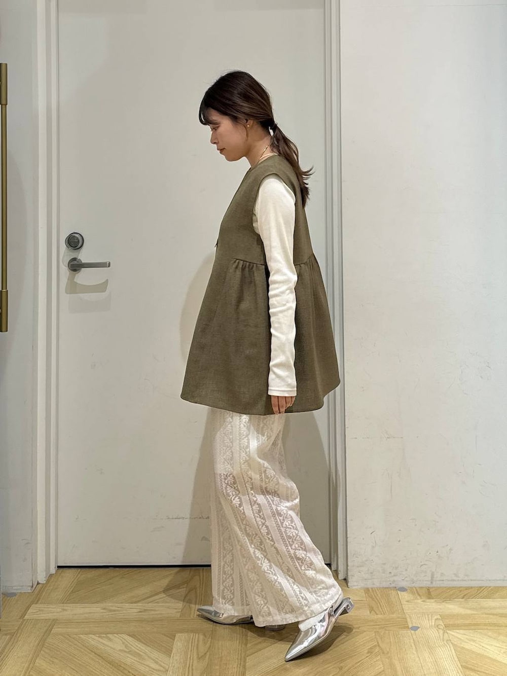 ブラウン系のベスト、ホワイト系のTシャツ/カットソー、シルバー系のトートバッグを着用したレディースの春コーディネートの4枚目の写真