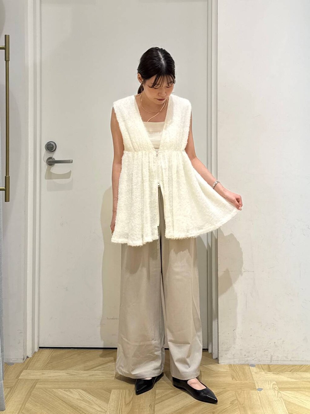 ベージュ系のその他パンツ、ブラック系のパンプス、ホワイト系のベストを着用したレディースの秋コーディネートの3枚目の写真