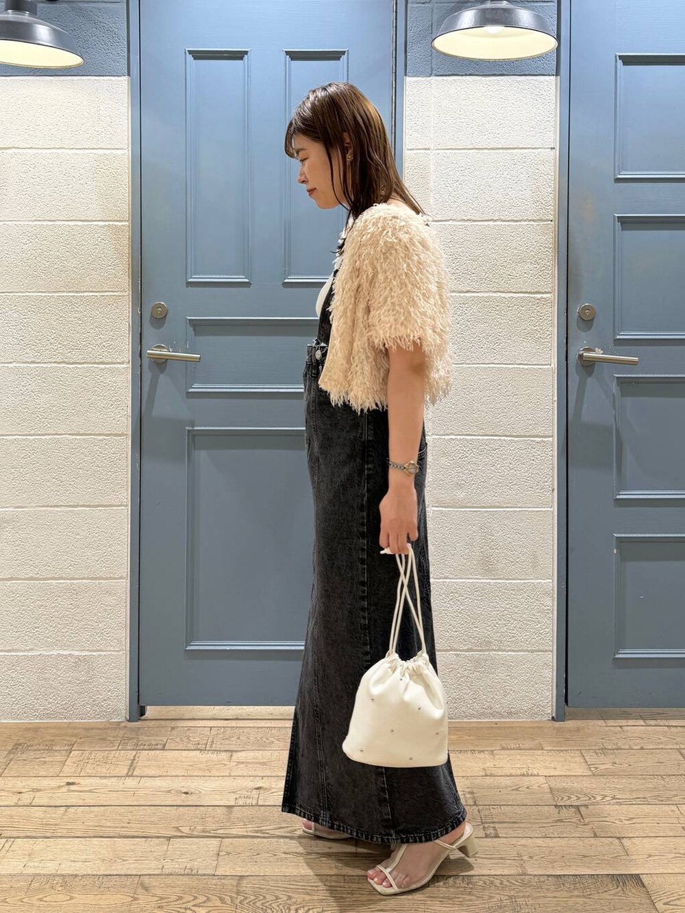 ホワイト系のショルダーバッグ、ホワイト系のタンクトップ、ホワイト系のサンダルを着用したレディースの夏コーディネートの2枚目の写真