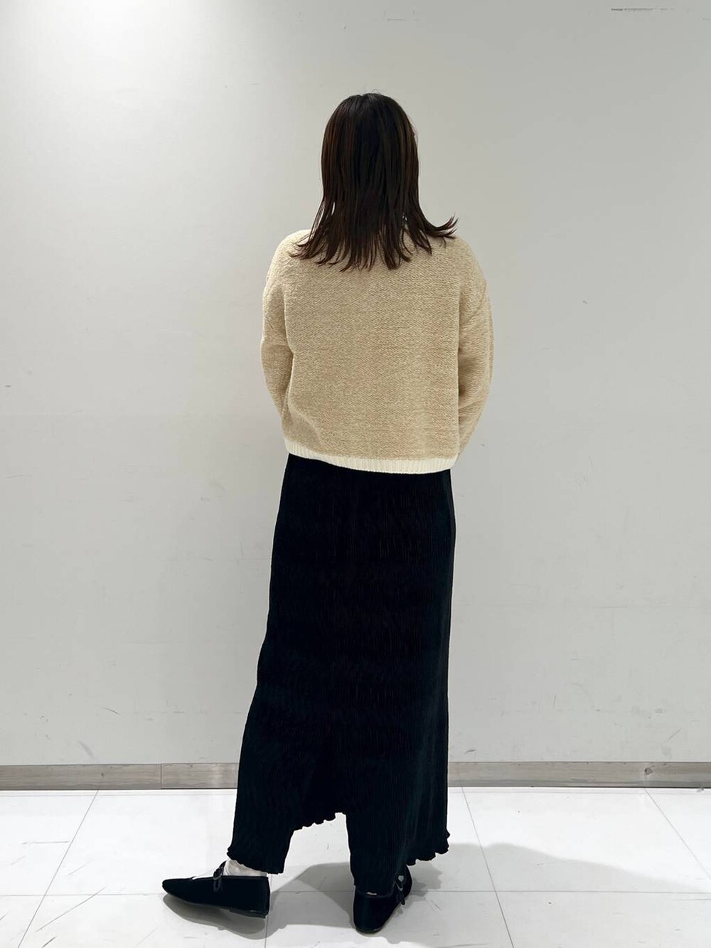 その他のパンプス、ホワイト系のカーディガン/ボレロ、ブラック系のスカートを着用したレディースの秋コーディネートの4枚目の写真