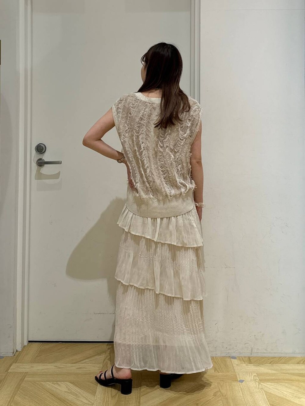 ブラック系のサンダル、ベージュ系のニット/セーター、ホワイト系のスカートを着用したレディースの夏コーディネートの4枚目の写真