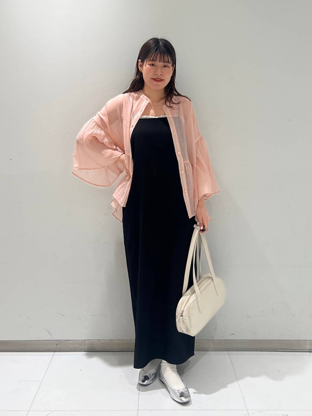 ホワイト系のハンドバッグ、グレー系のバレエシューズ、ブラック系のワンピースを着用したレディースの春コーディネートの2枚目の写真