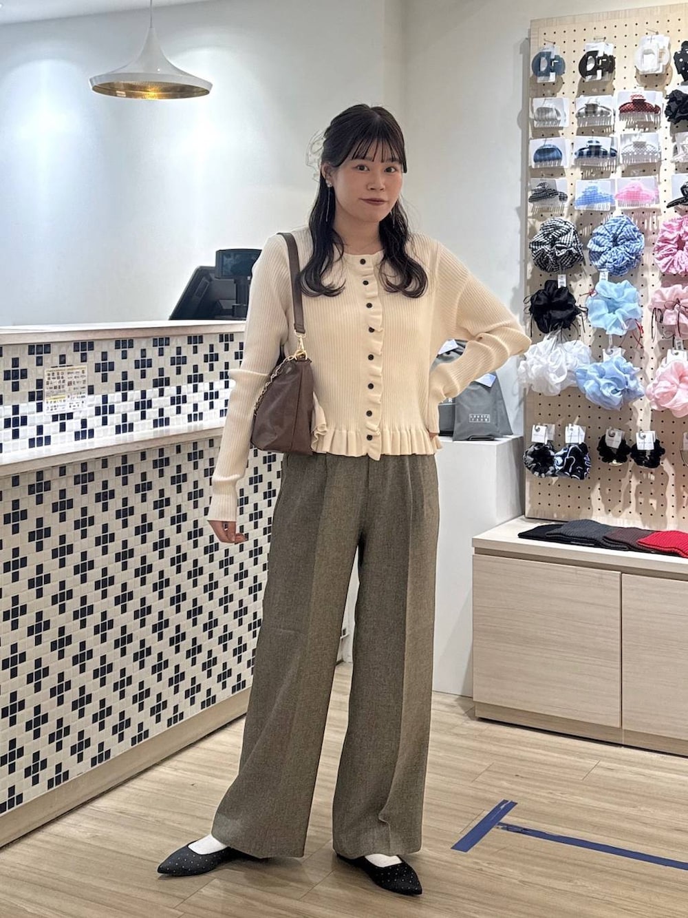 ブラック系のパンプス、ベージュ系のショルダーバッグ、ホワイト系のTシャツ/カットソーを着用したレディースの春コーディネートの2枚目の写真