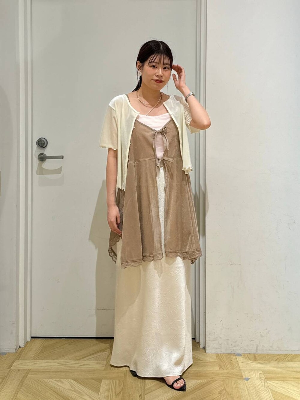 ブラック系のサンダル、ホワイト系のスカート、ホワイト系のカーディガン/ボレロを着用したレディースの夏コーディネートの6枚目の写真