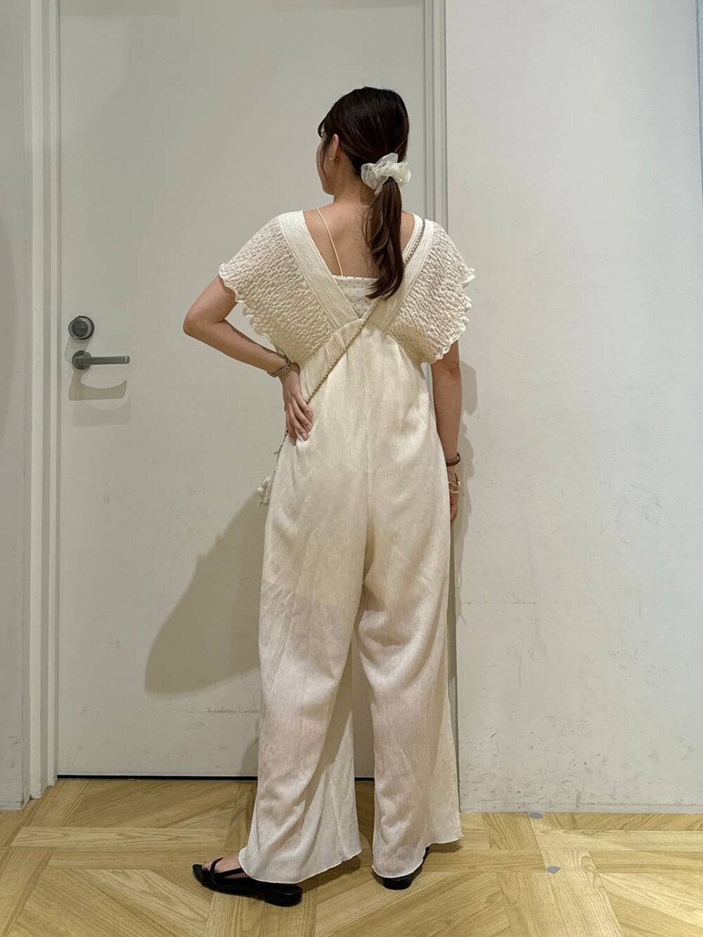 ゴールド系のショルダーバッグ、ブラック系のサンダル、ホワイト系のサロペット/オーバーオールを着用したレディースの夏コーディネートの6枚目の写真