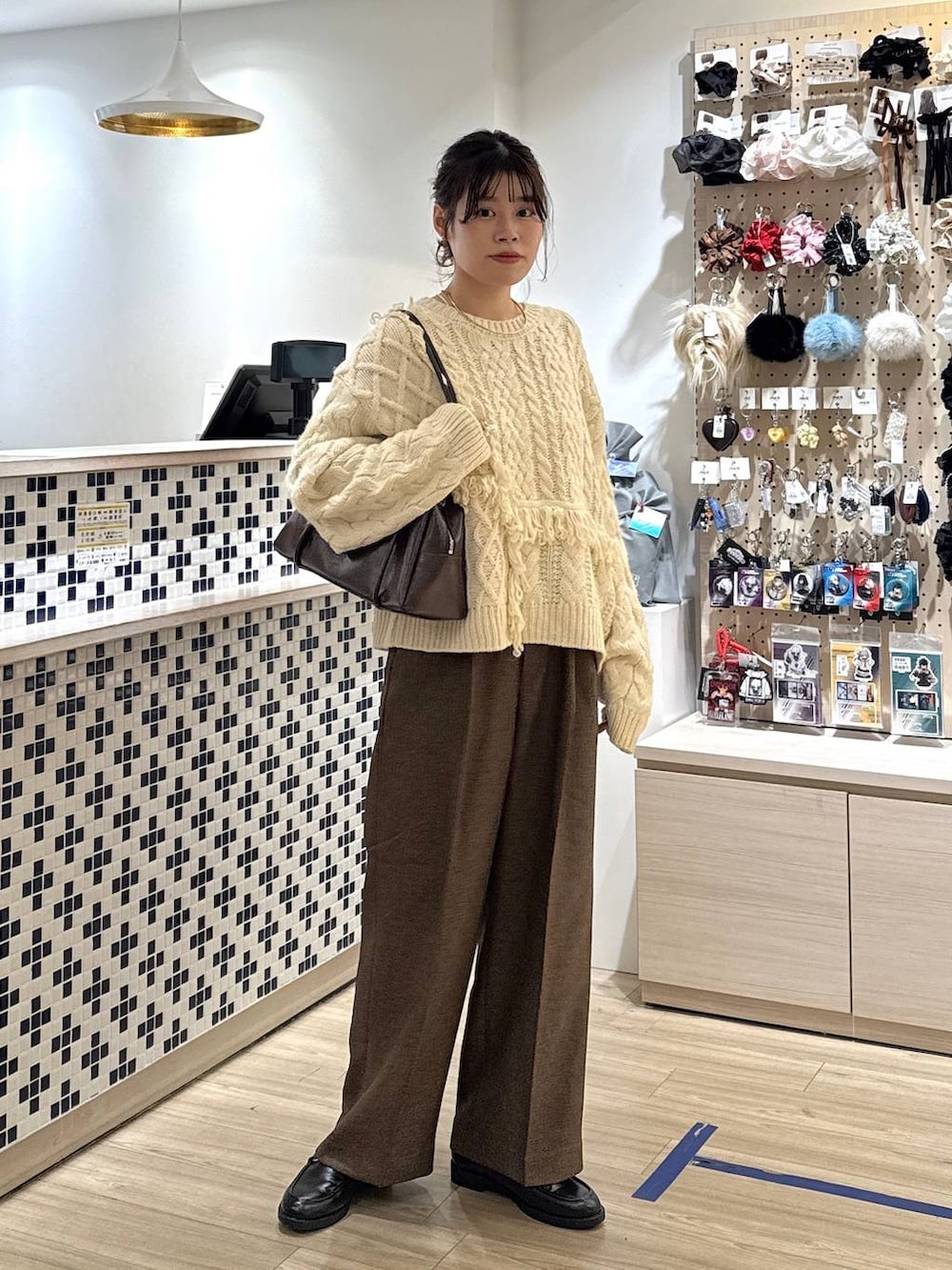 ブラウン系のその他パンツ、ブラック系のローファー、ホワイト系のポロシャツを着用したレディースの秋コーディネートの2枚目の写真