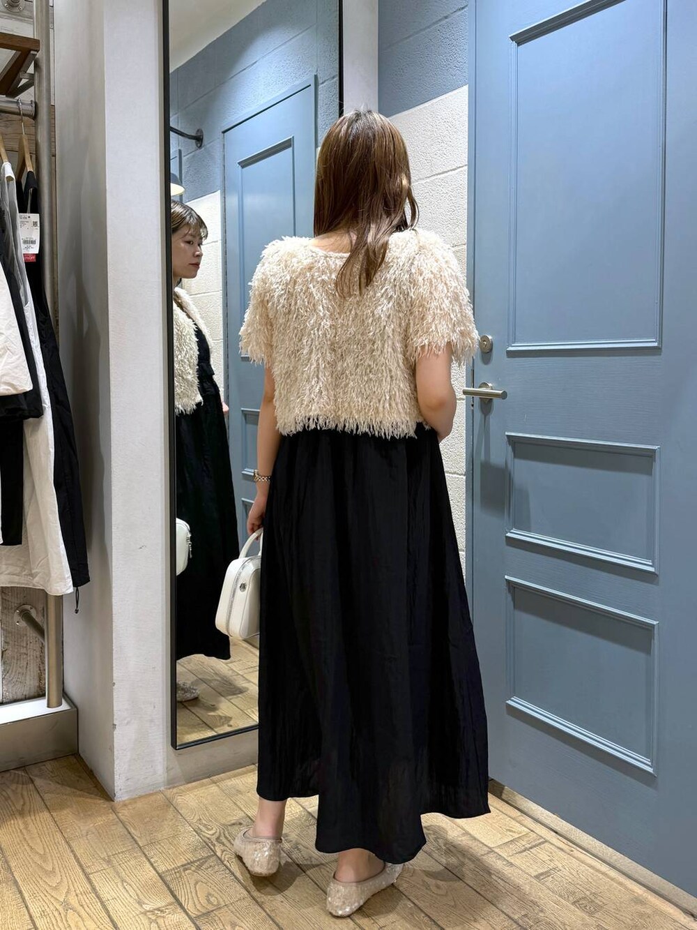 ホワイト系のボストンバッグ、ホワイト系のバレエシューズ、ブラック系のワンピースを着用したレディースの夏コーディネートの3枚目の写真