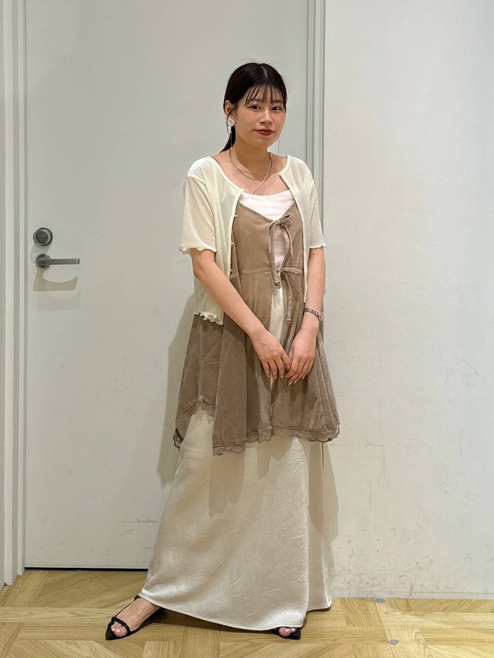 ブラック系のサンダル、ホワイト系のスカート、ホワイト系のカーディガン/ボレロを着用したレディースの夏コーディネートの7枚目の写真