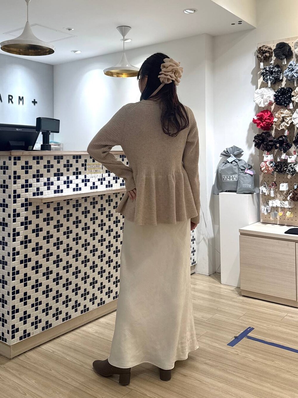 ホワイト系のスカート、ベージュ系のカーディガン/ボレロ、ブラウン系のブーツを着用したレディースの冬コーディネートの7枚目の写真