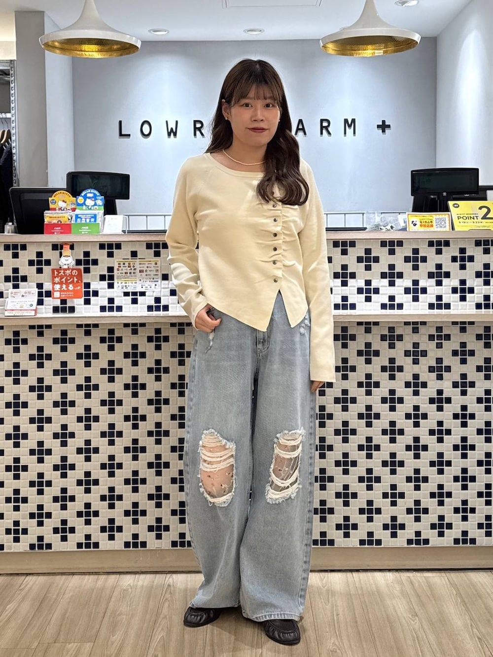 ホワイト系のニット/セーター、ブラウン系のローファー、ブルー系のデニムパンツを着用したレディースの秋コーディネートの2枚目の写真