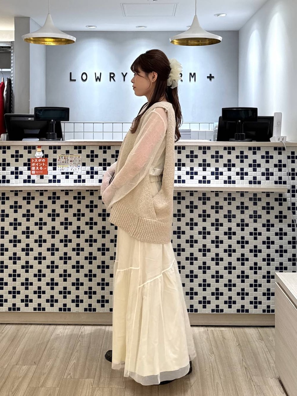 ブラウン系のローファー、ブラウン系のトートバッグ、ホワイト系のスカートを着用したレディースの春コーディネートの3枚目の写真