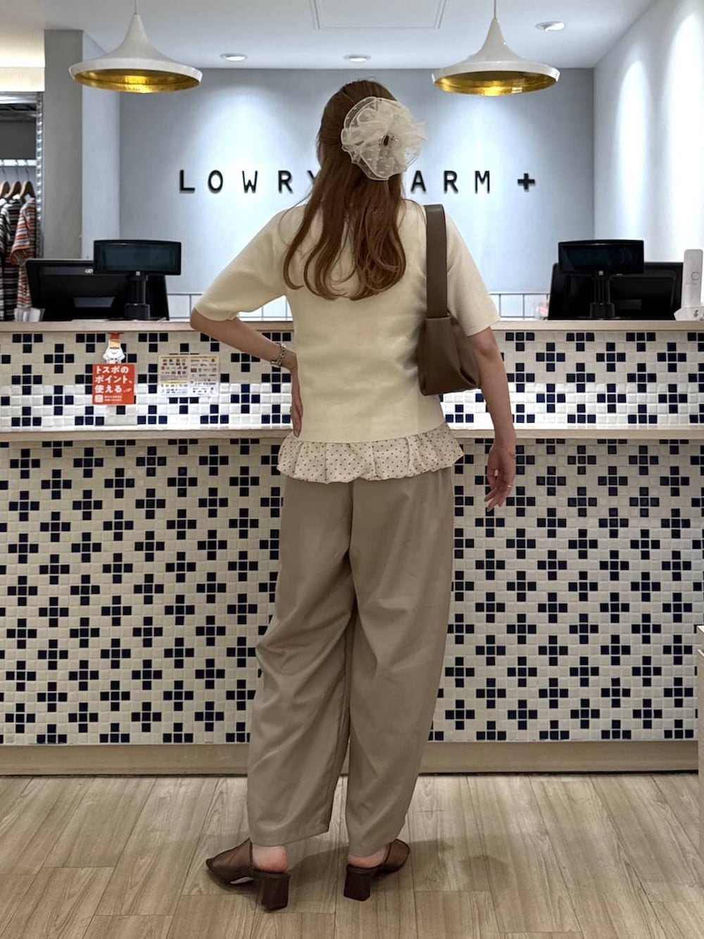 ベージュ系のその他パンツ、ブラウン系のショルダーバッグ、ブラウン系のサンダルを着用したレディースの夏コーディネートの5枚目の写真