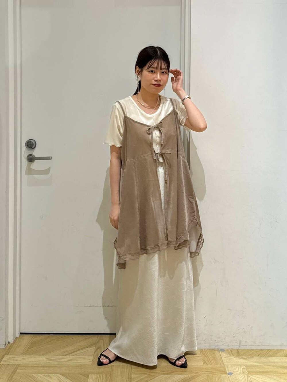 ブラック系のサンダル、ホワイト系のスカート、ホワイト系のカーディガン/ボレロを着用したレディースの夏コーディネートの3枚目の写真