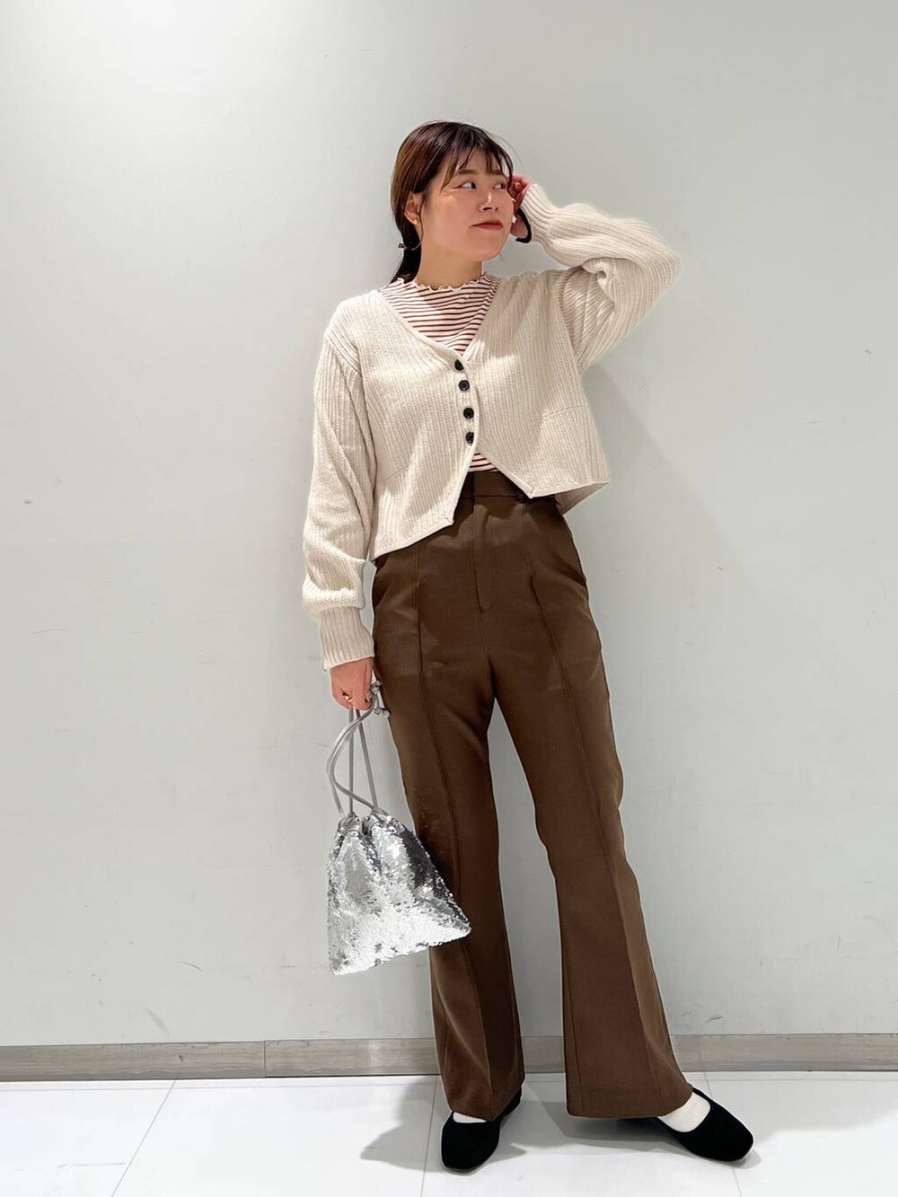 ブラウン系のTシャツ/カットソー、その他のパンプス、シルバー系のハンドバッグを着用したレディースの秋コーディネートの2枚目の写真