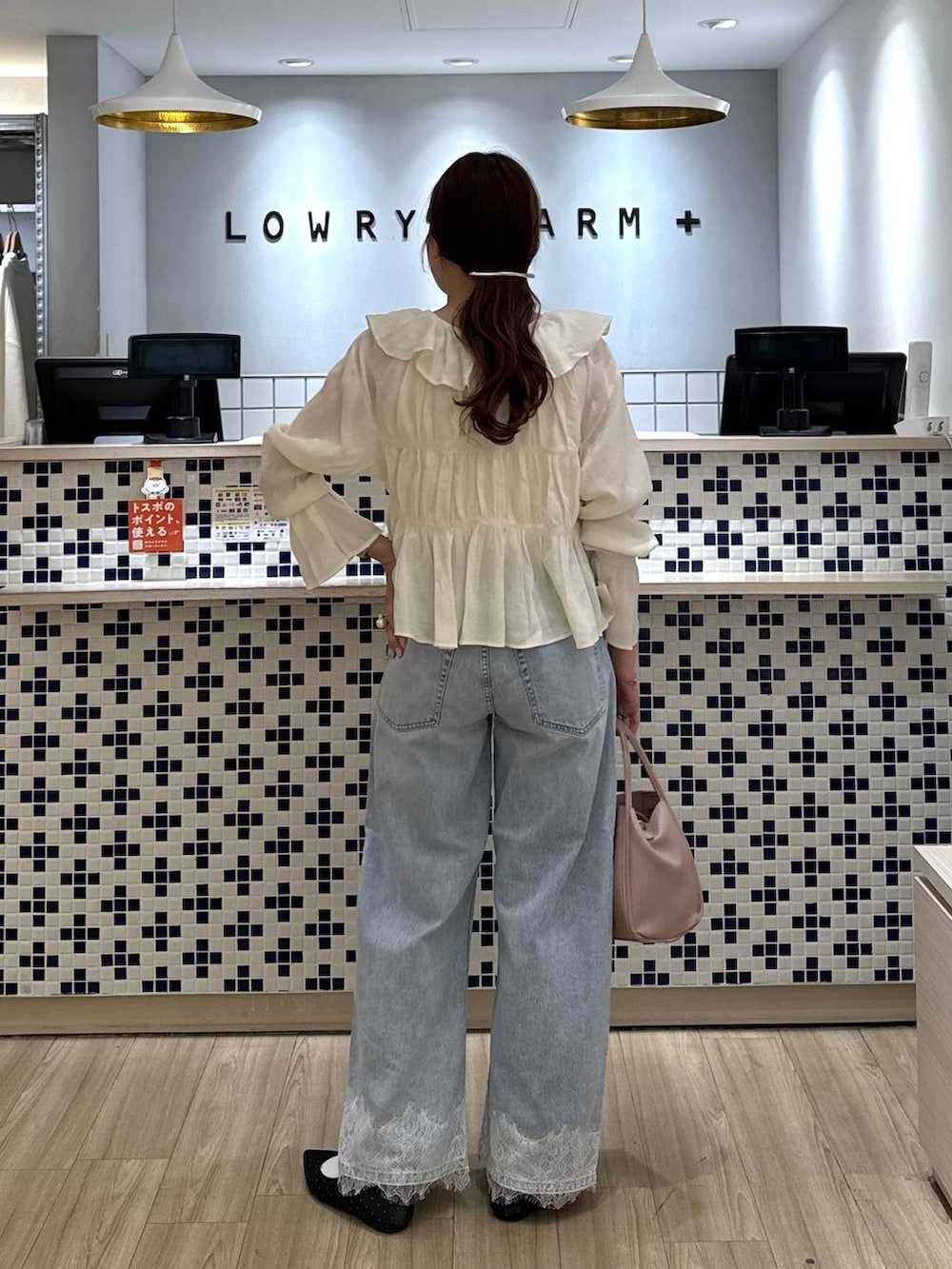 ホワイト系のショルダーバッグ、ブラック系のパンプス、ブルー系のデニムパンツを着用したレディースの春コーディネートの4枚目の写真