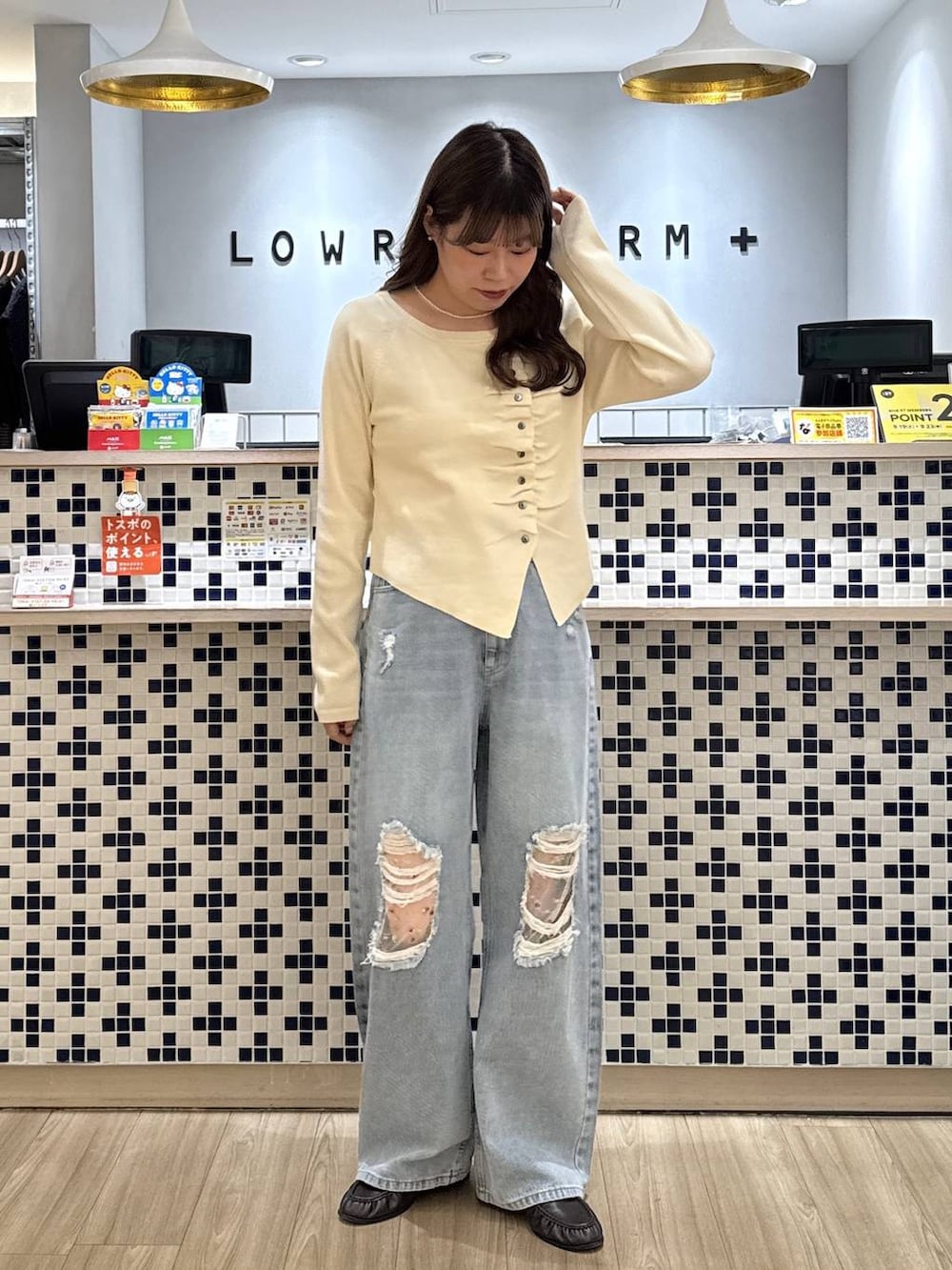ホワイト系のニット/セーター、ブラウン系のローファー、ブルー系のデニムパンツを着用したレディースの秋コーディネートの3枚目の写真