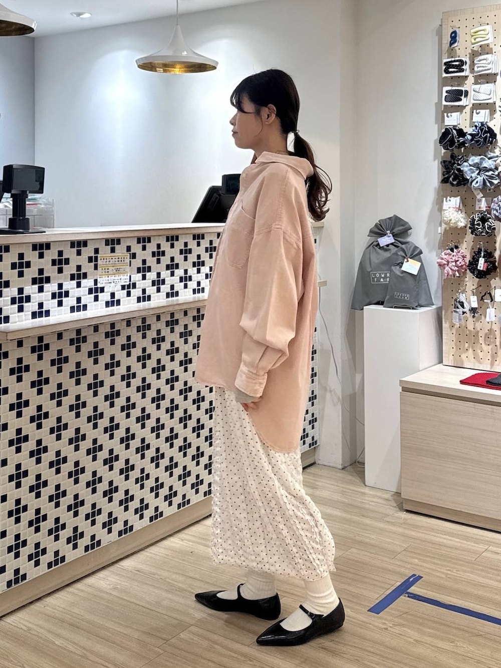 ブラック系のパンプス、ピンク系のシャツ/ブラウス、ブラウン系のショルダーバッグを着用したレディースの春コーディネートの2枚目の写真