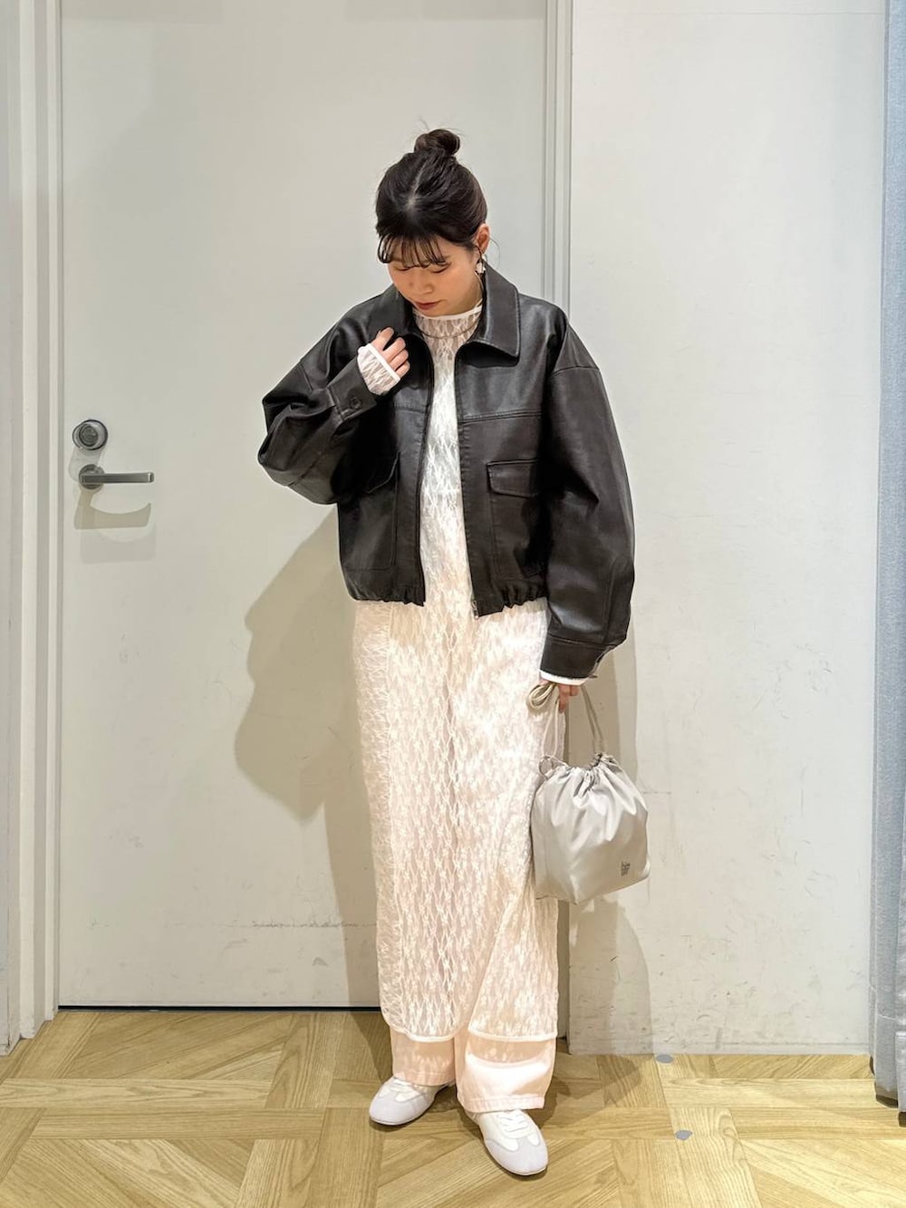 ピンク系のデニムパンツ、ホワイト系のショルダーバッグ、ホワイト系のスニーカーを着用したレディースの春コーディネートの3枚目の写真