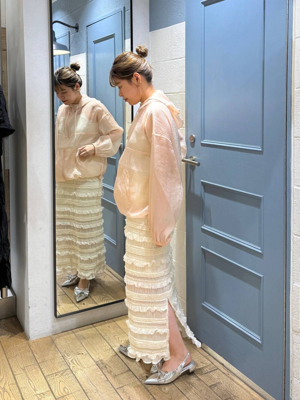 シルバー系のパンプス、ピンク系のシャツ/ブラウス、ホワイト系のスカートを着用したレディースの夏コーディネートの3枚目の写真