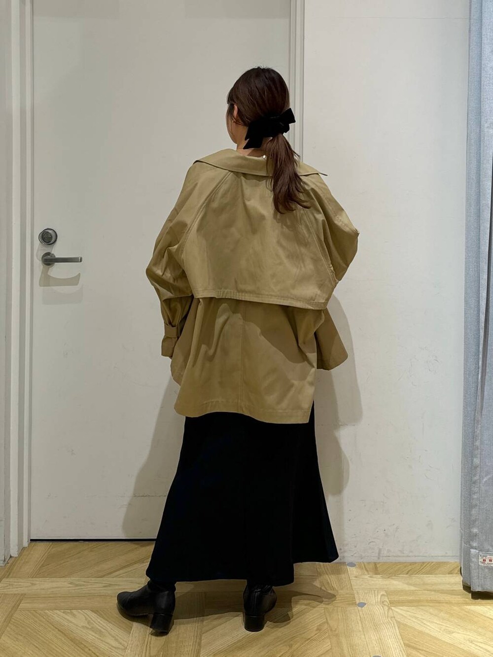 ブラック系のブーツ、ホワイト系のシャツ/ブラウス、ブラウン系のトレンチコートを着用したレディースの春コーディネートの5枚目の写真