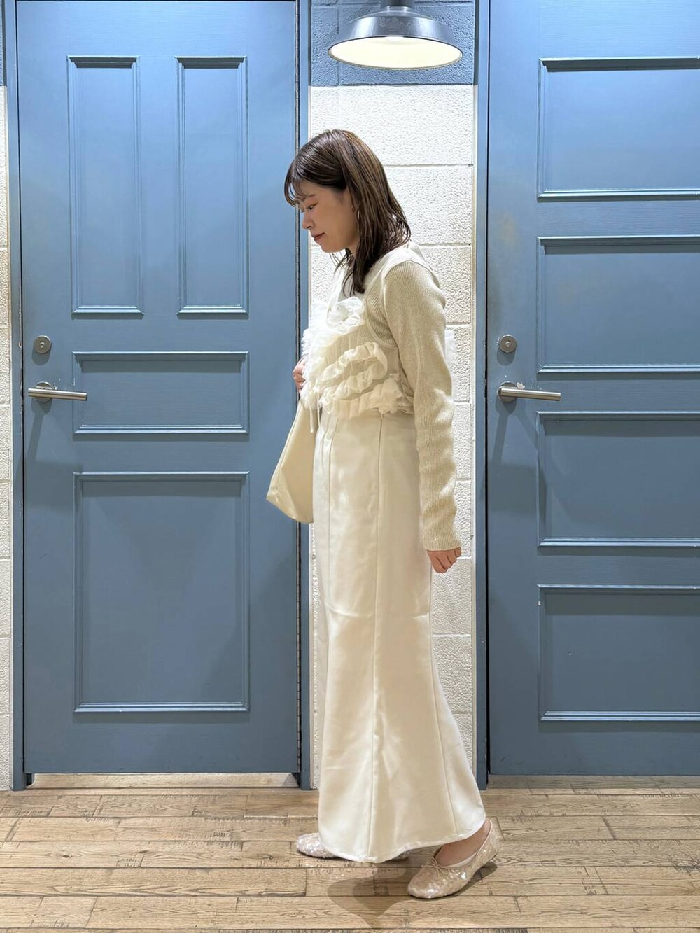 ホワイト系のショルダーバッグ、ホワイト系のバレエシューズ、ホワイト系のキャミソールを着用したレディースの秋コーディネートの4枚目の写真