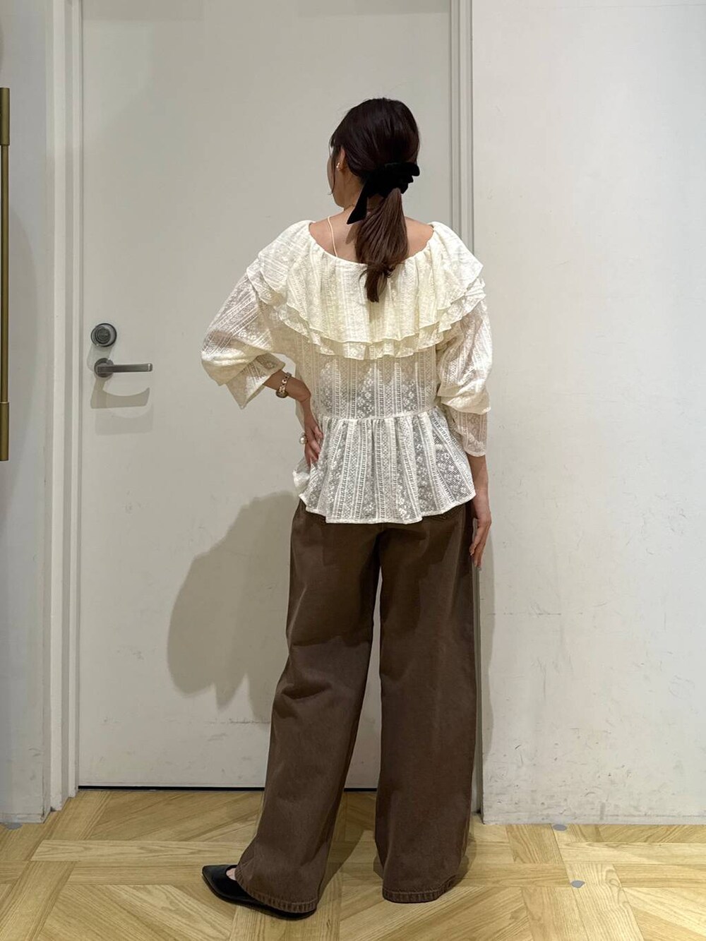 ブラウン系のデニムパンツ、ブラック系のパンプス、ホワイト系のシャツ/ブラウスを着用したレディースの夏コーディネートの6枚目の写真