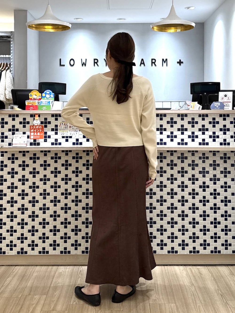 ブラウン系のスカート、ホワイト系のニット/セーターを着用したレディースの秋コーディネートの4枚目の写真