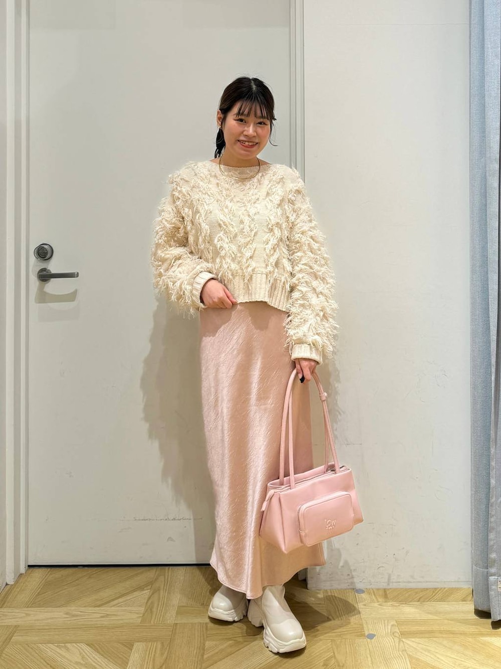 ホワイト系のブルゾン、ピンク系のショルダーバッグ、ホワイト系のブーツを着用したレディースの冬コーディネートの6枚目の写真