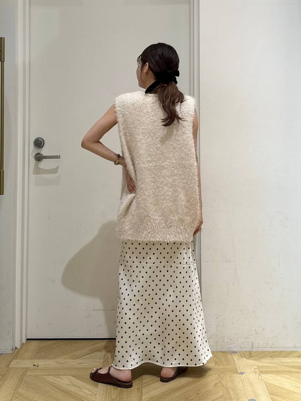 ホワイト系のスカート、ブラウン系のサンダル、ホワイト系のベストを着用したレディースの夏コーディネートの4枚目の写真