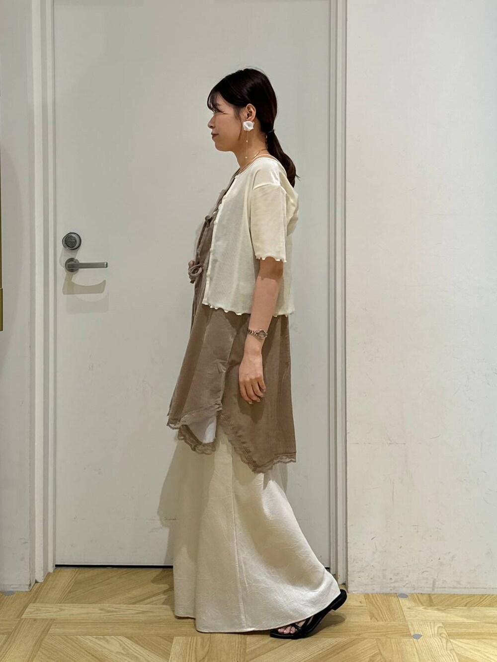 ブラック系のサンダル、ホワイト系のスカート、ホワイト系のカーディガン/ボレロを着用したレディースの夏コーディネートの8枚目の写真