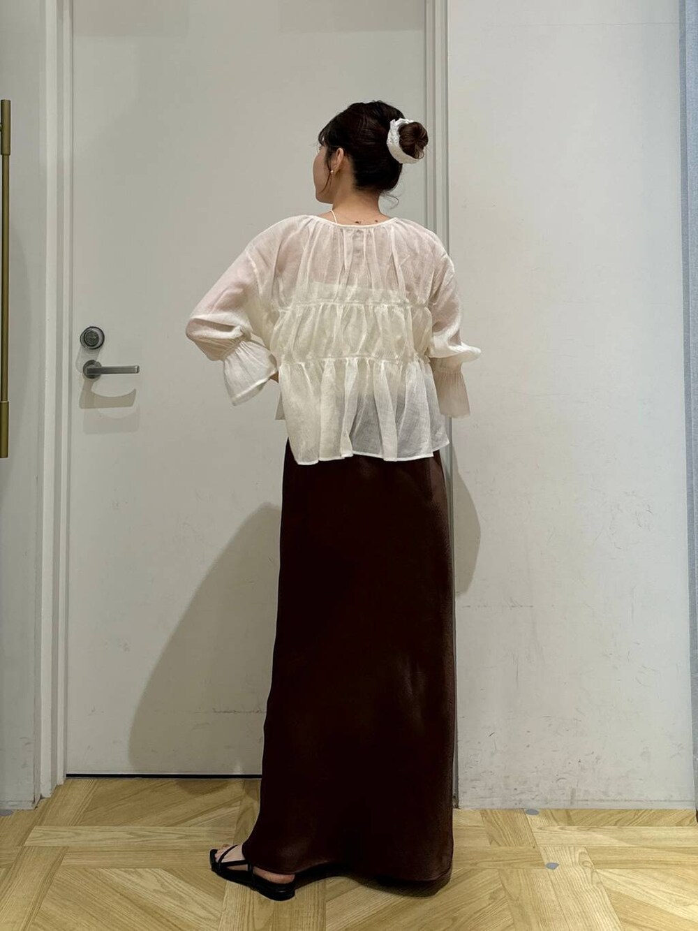 ブラック系のサンダル、ホワイト系のシャツ/ブラウス、ブラウン系のスカートを着用したレディースの夏コーディネートの4枚目の写真