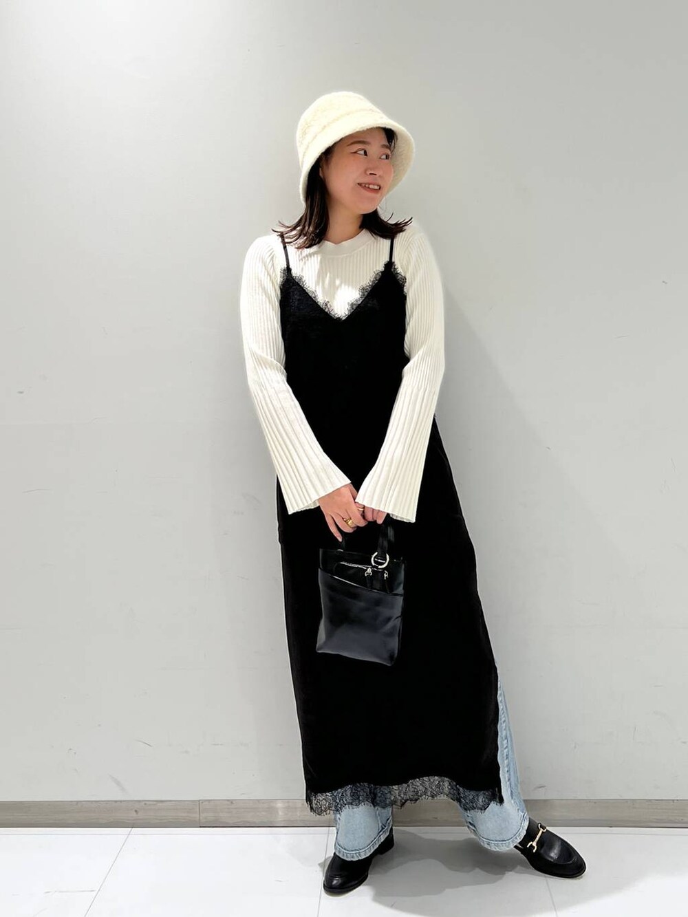 ブルー系のデニムパンツ、ブラック系のローファー、ホワイト系のニット/セーターを着用したレディースの秋コーディネートの2枚目の写真