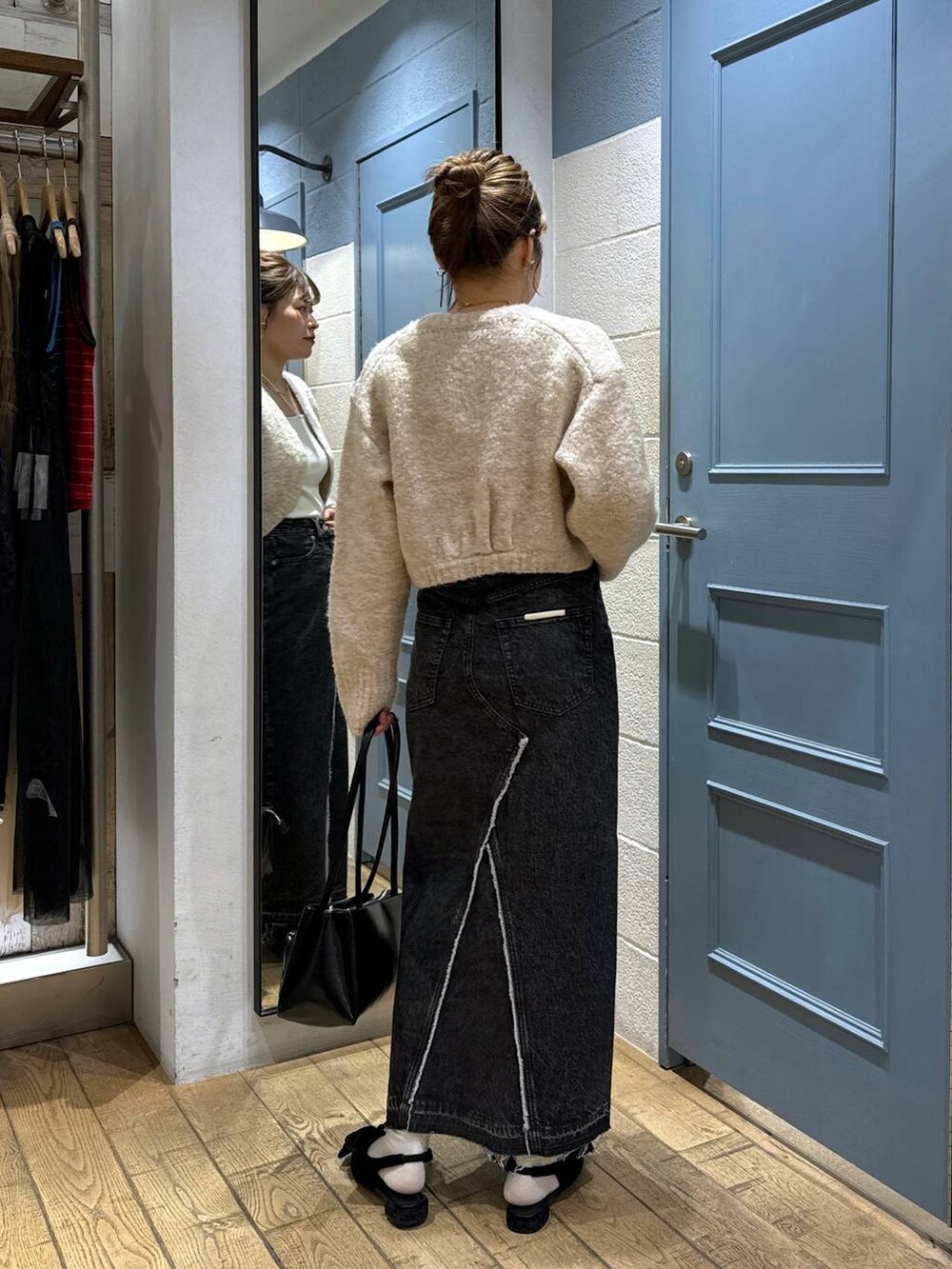 ブラック系のパンプス、ホワイト系のキャミソール、ブラック系のスカートを着用したレディースの秋コーディネートの3枚目の写真