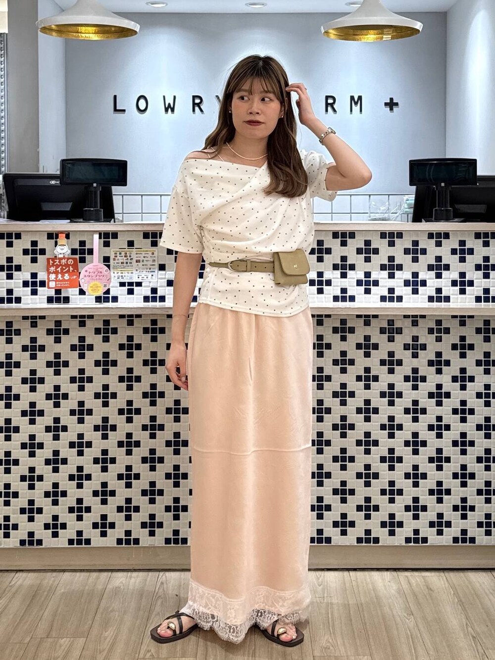 ベージュ系のTシャツ/カットソー、ブラウン系のサンダル、ピンク系のスカートを着用したレディースの夏コーディネートの2枚目の写真