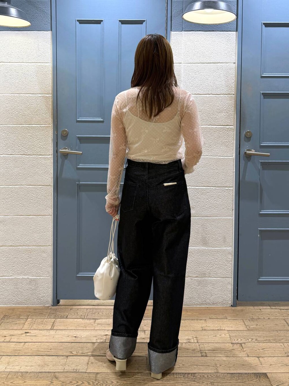 ホワイト系のショルダーバッグ、グレー系のデニムパンツ、ホワイト系のタンクトップを着用したレディースの夏コーディネートの3枚目の写真